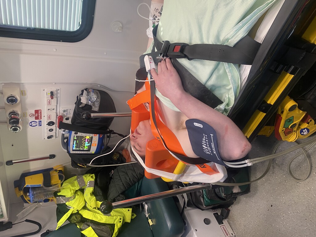 Ben on a stretcher in the back of the abulance