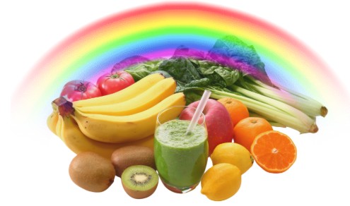 rainbow in the background with lots of vegetables and fruit a a glass with green smoothy and a straw